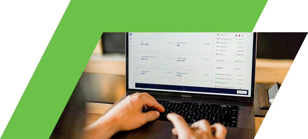 A person is using a laptop to analyze financial metrics displayed on a data dashboard.