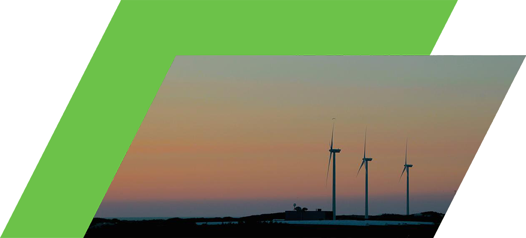 Silhouettes of wind turbines against a colorful sunset sky.