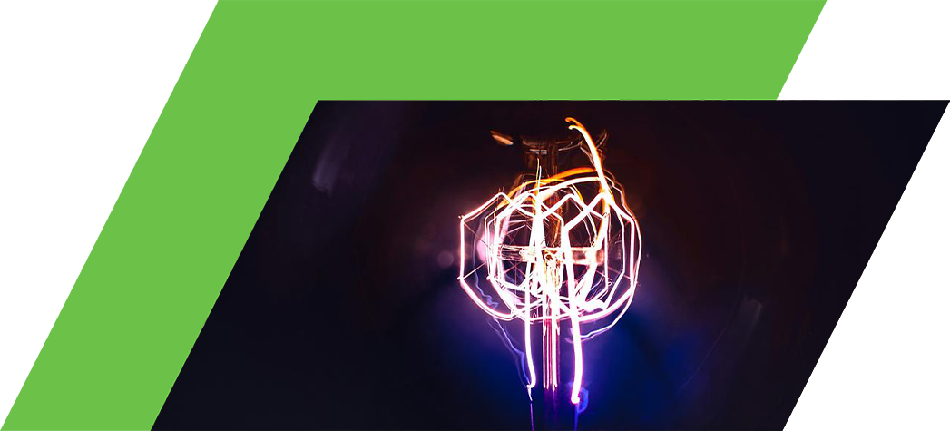 A close-up of a vintage light bulb with colorful glowing filaments against a dark background.