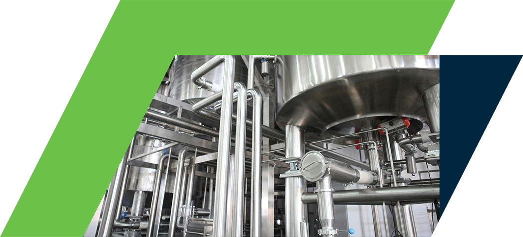 Industrial equipment featuring stainless steel tanks and piping in a manufacturing facility.