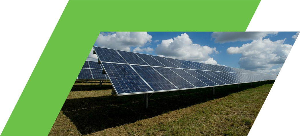 A row of solar panels stands in a grassy field under a blue sky with fluffy white clouds.