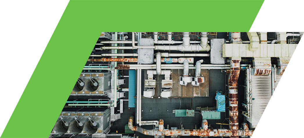 Aerial view of a complex industrial facility featuring numerous pipes, cooling units, and machinery.