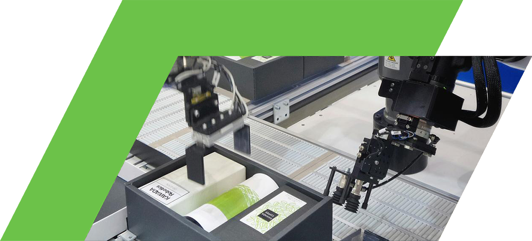 Two robotic arms are interacting with items on a conveyor belt in a manufacturing setting.
