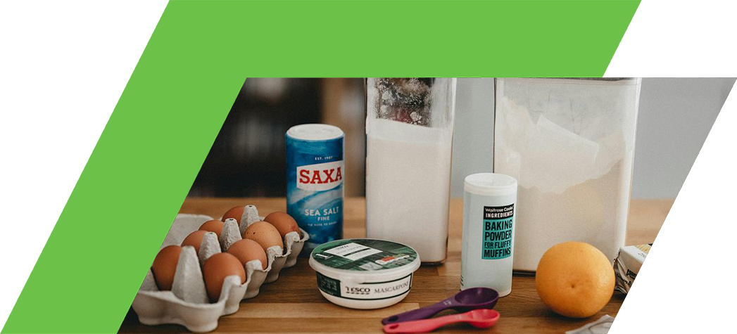 Carton with eggs, orange, and other ingredients to make cake 