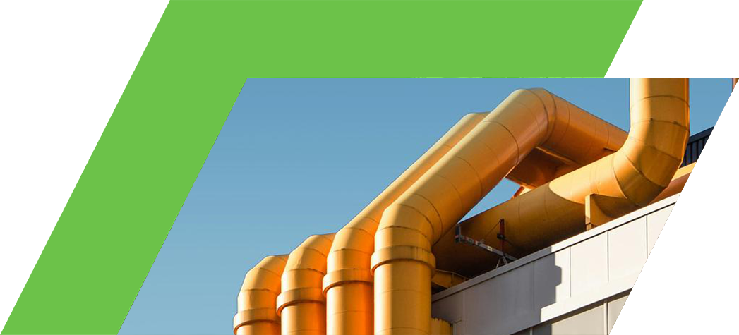 A close-up view of large yellow pipes extending from the top of a modern building against a clear blue sky.