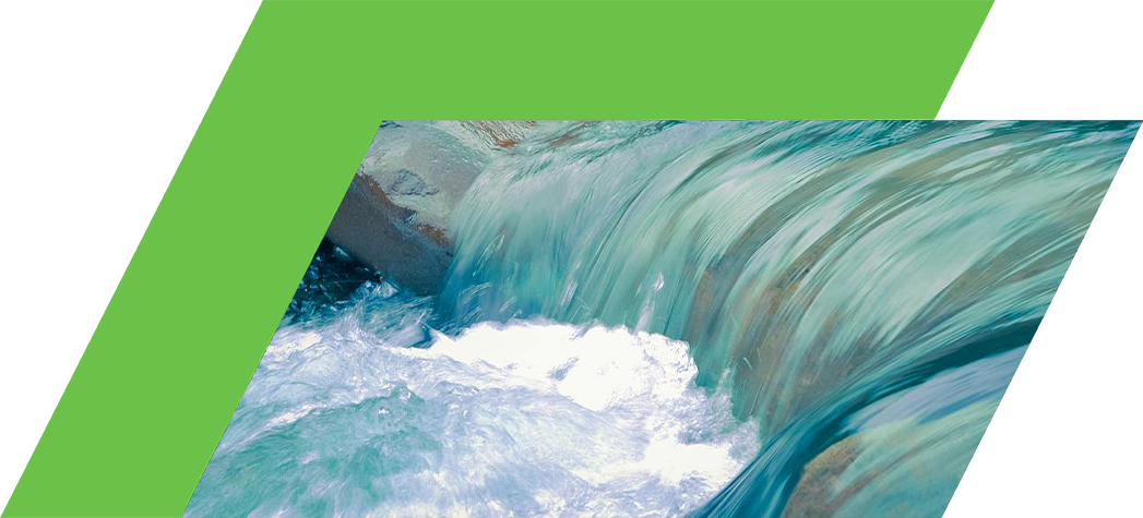 A close-up of clear water cascading over smooth stones in a serene natural setting.