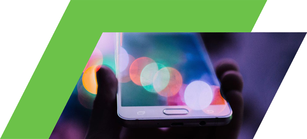 A hand holding a smartphone with a blurred, colorful background of lights.