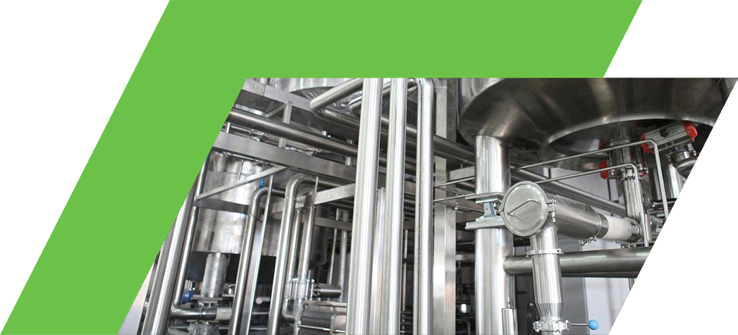 Industrial stainless steel machinery with pipes and tanks in a processing facility.