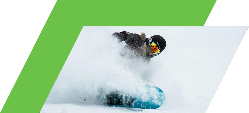 A snowboarder carves through deep powder snow on a winter day.