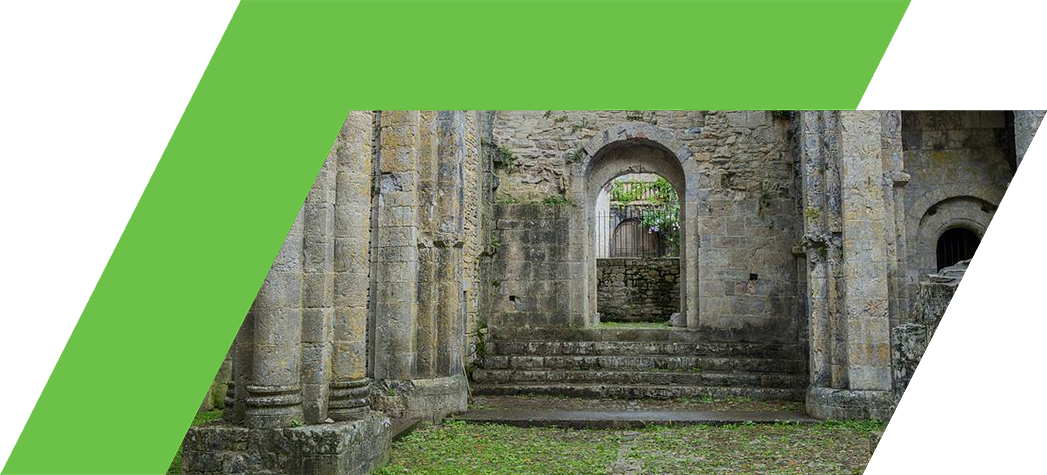 Ruins of an ancient stone structure with arches and greenery.