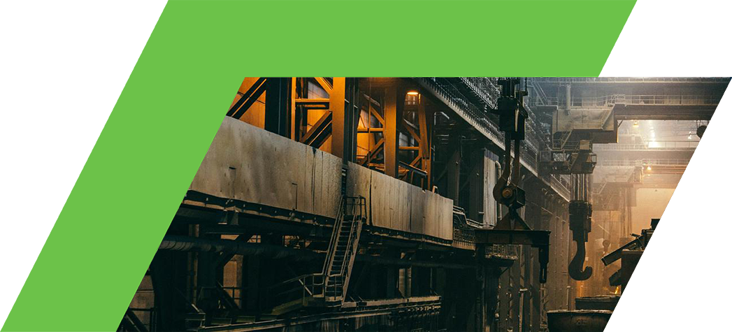 Industrial interior of a factory with large machinery and dim lighting.