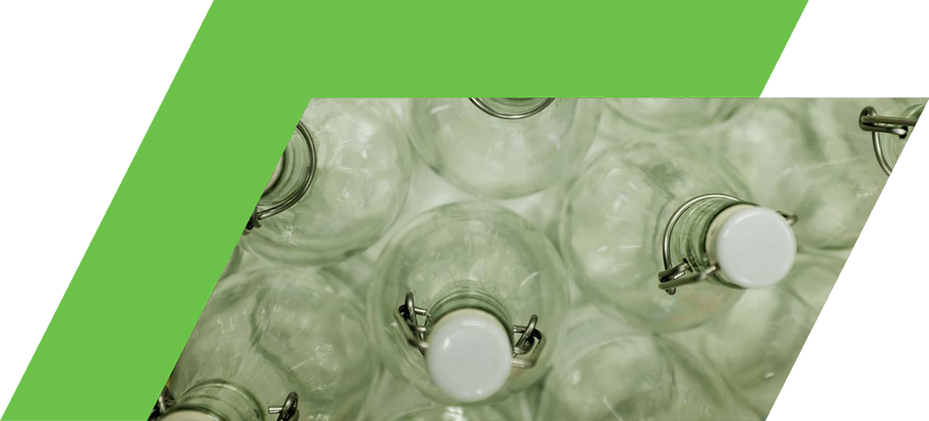 A top-down view of multiple clear glass bottles with white caps arranged closely together.