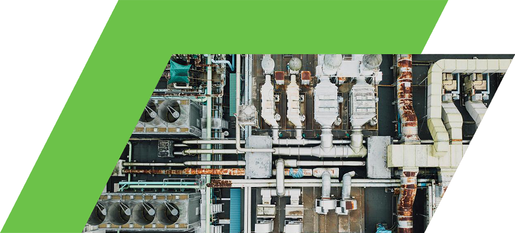 An aerial view of a complex industrial facility featuring pipes, cooling units, and machinery.