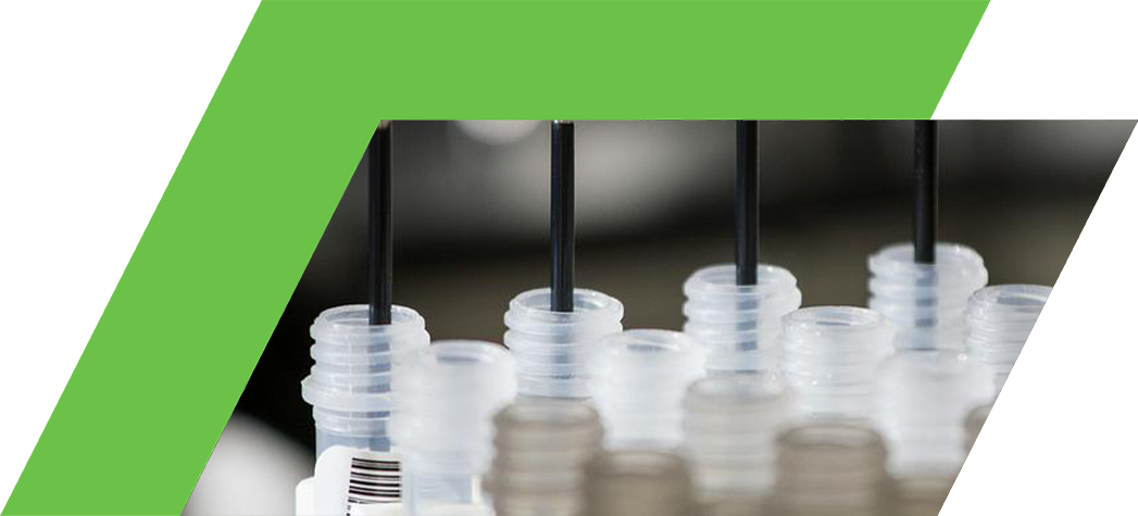 Close-up of laboratory equipment dispensing liquid into multiple small containers.