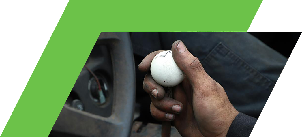 A close-up of a hand gripping a white gear shift knob inside a vehicle.