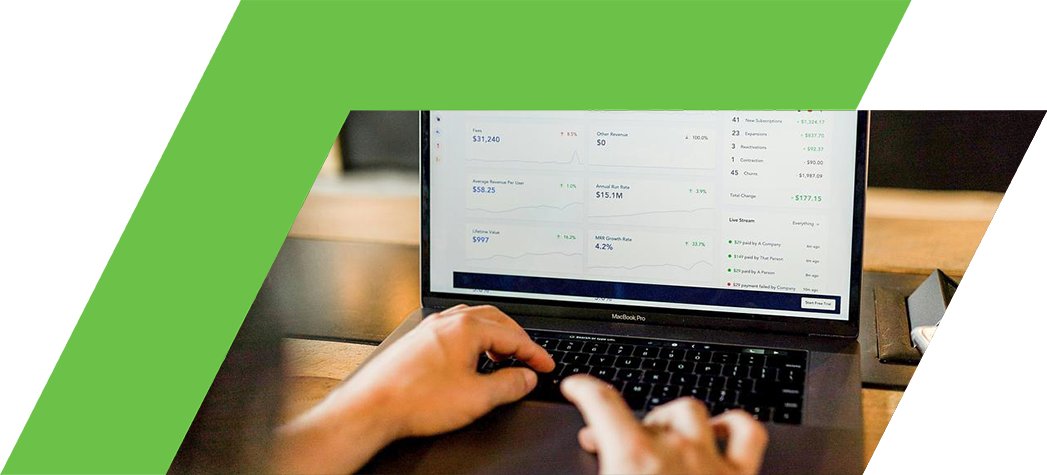 A person is using a laptop to view financial metrics and analytics on a screen.
