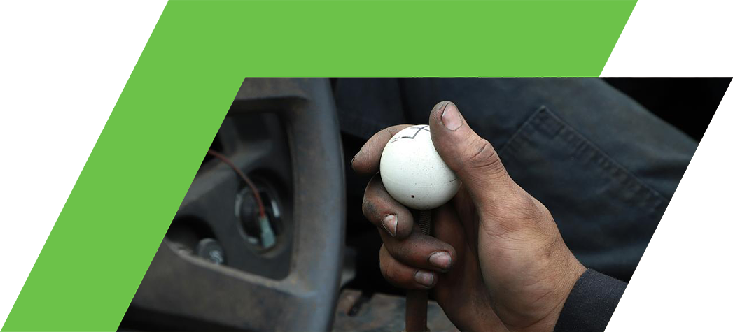 A close-up of a hand gripping a white spherical gear shift knob inside a vehicle.