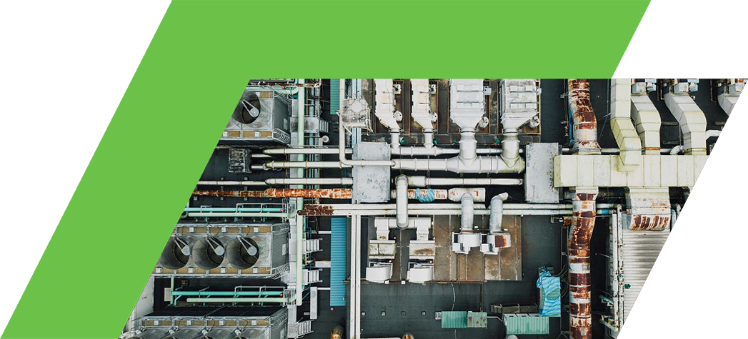 An overhead view of a complex industrial facility featuring pipes, cooling units, and machinery.