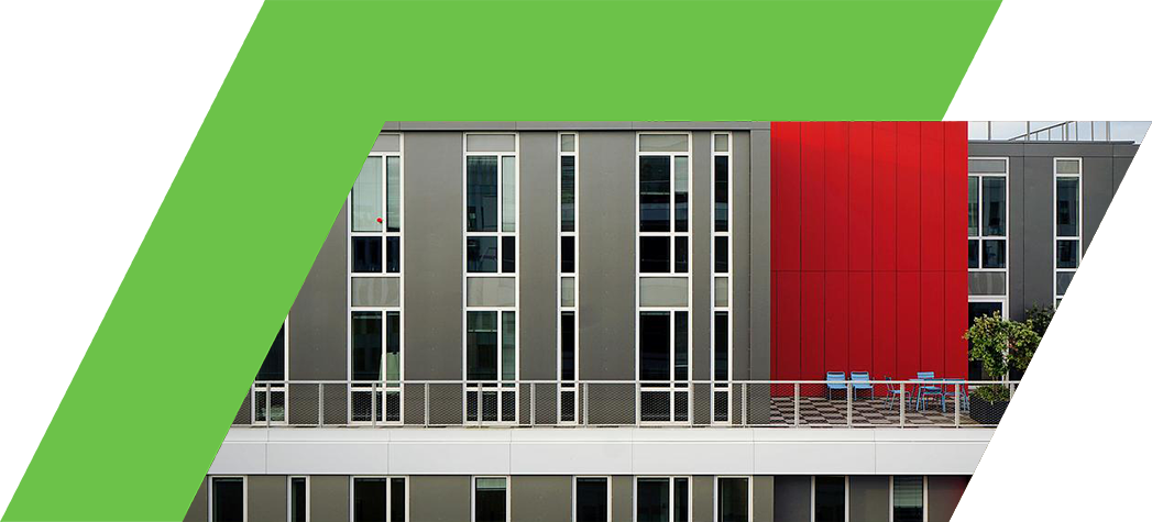 A modern building featuring a striking red wall and large windows.