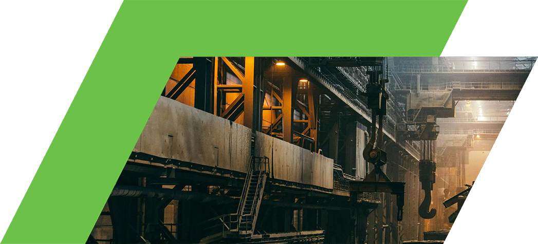 Interior of a large industrial facility with heavy machinery and ambient lighting.