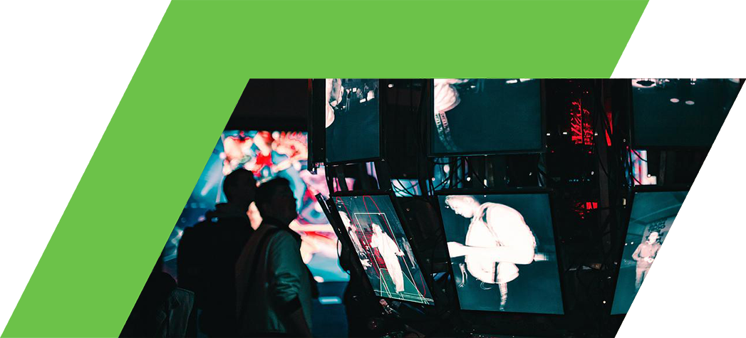 A creative display of multiple screens showcasing black-and-white images in a dimly lit environment with people in the background.