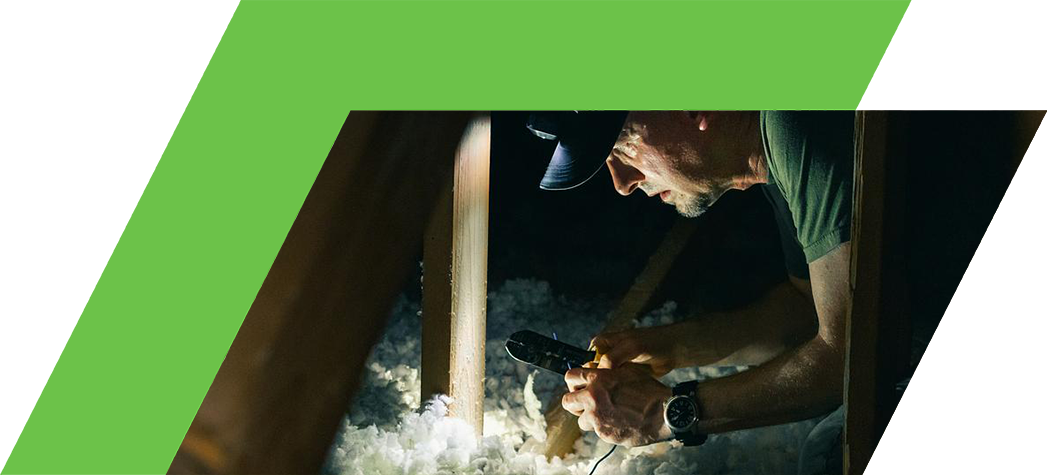 A man working insulating a roof.