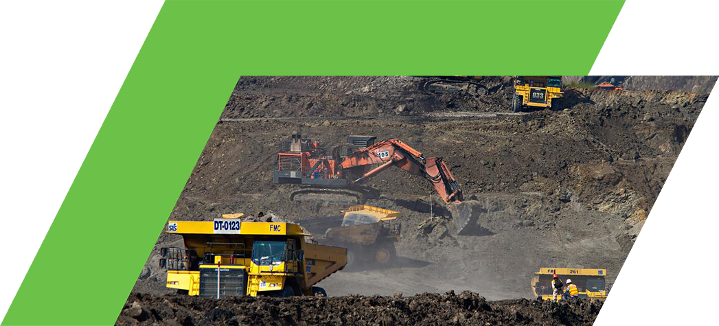 A busy mining site featuring heavy machinery, including excavators and dump trucks, working on a rocky terrain.