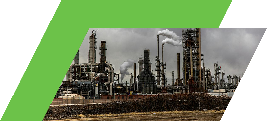 Industrial oil refinery with smokestacks against a cloudy sky.